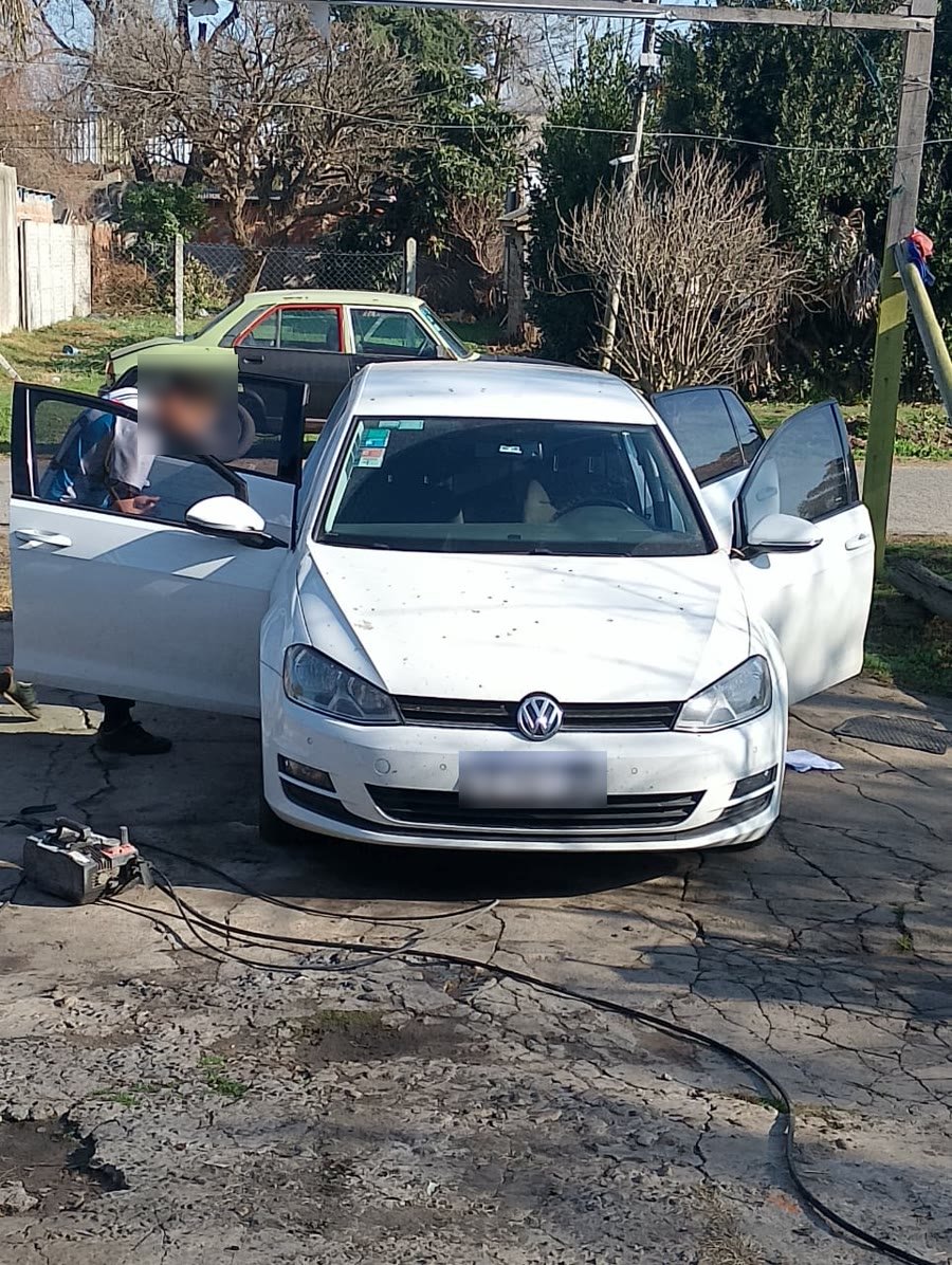 Limpiando por dentro un Volkswagen Golf blanco con las puertas abiertas