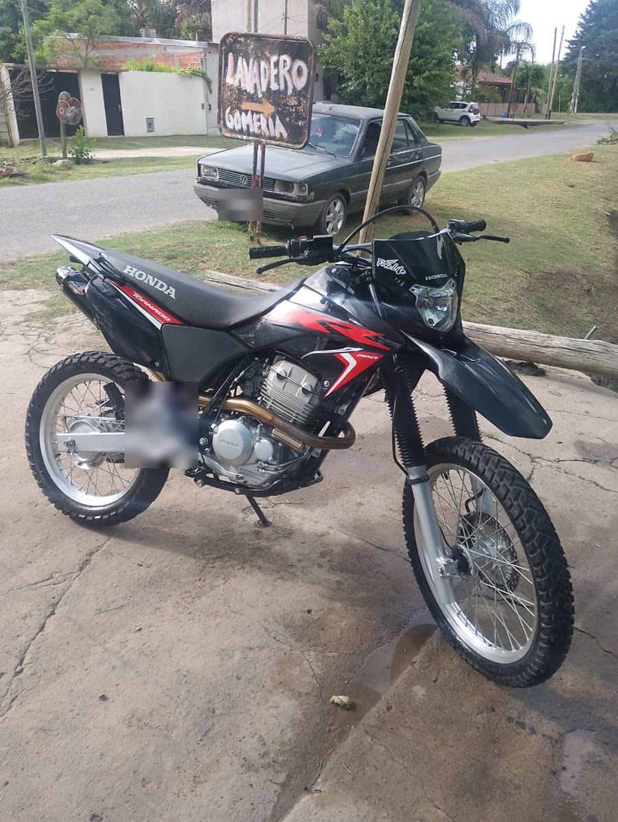Una moto Honda frente al cartel de Lavadero y Gomería